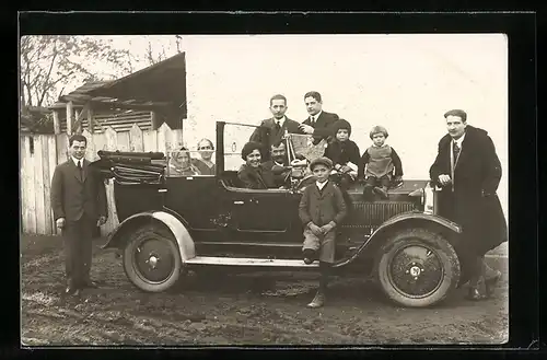 Foto-AK Auto, KFZ mit grosser Familie darin und darum herum