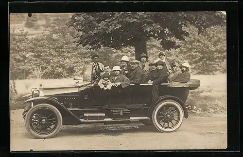 Foto-AK Auto, vollbesetztes Fahrzeug an einem Baum