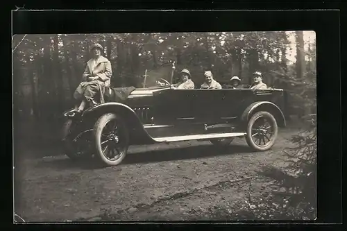 Foto-AK Auto, Vier Leute im Fahrzeug, eine Frau sitzt auf der Motorhaube