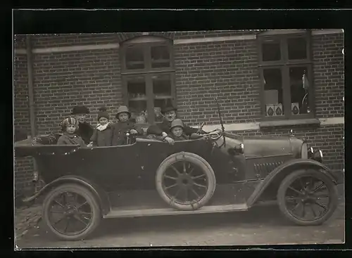 Foto-AK Auto, Zwei Eltern mit vier Kindern im KFZ