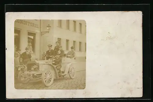 Foto-AK Auto, Vollbesetztes kleines KFZ vor einem Konditorei-Geschäft