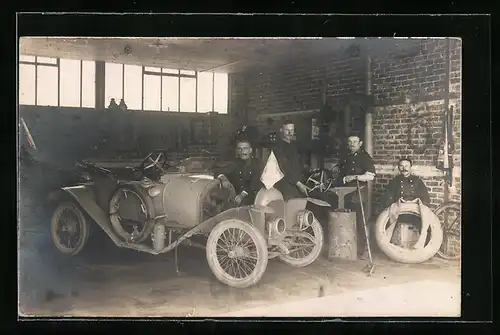 Foto-AK Auto, Vier uniformierte Soldaten mit einem KFZ in einer Garage