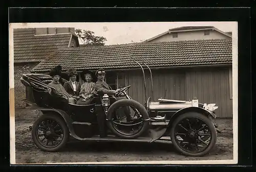 Foto-AK Auto, Chauffeur mit zwei Damen und einem Mädchen im Auto