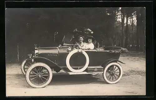 Foto-AK Auto, Bürgerliches Ehepaar im KFZ mit offenem Verdeck, die Frau am Steuer