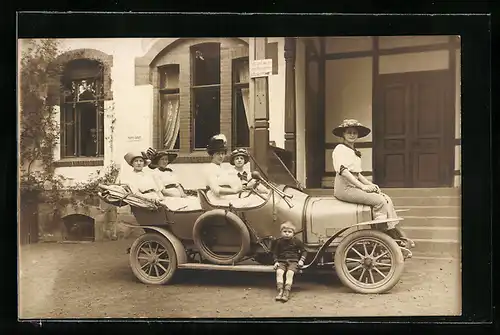 Foto-AK Auto Praga oder K.A.N., Vier Frauen im KFZ, eine auf der Motorhaube, ein Kind auf dem Trittbrett