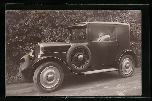 AK Auto, Junger Mann im schwarzen KFZ mit seitlichen Ersatzreifen