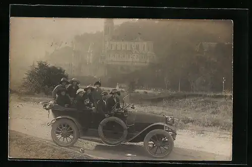 Foto-AK Auto, 8 Leute in einem vollbesetzten KFZ vor einer Kirche