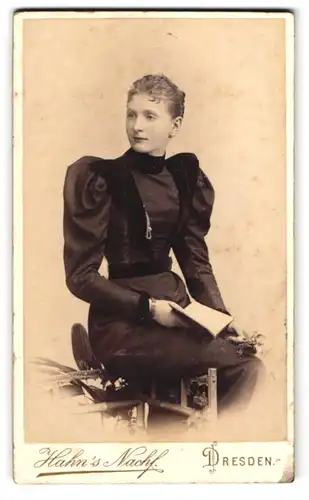 Fotografie Hahns Nachfl., Dresden, Waisenhaus-Strasse 16, Junge Frau im taillierten schwarzen Kleid mit Puffärmeln