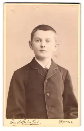 Fotografie Emil Schuffer, Borna, Am Bahnhof, Knabe mit kurzgeschorenen Haaren in geschlossener Anzugjacke