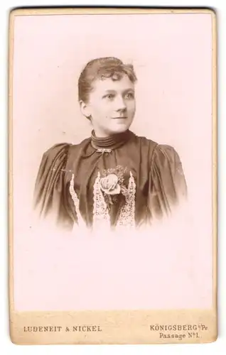 Fotografie Ludenheit & Nickel, Königsberg i. Pr., Passage 1, Jugendliches Mädchen im schwarzen Kleid mit Ansteckrose
