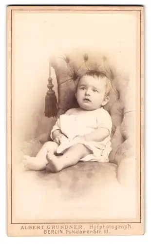 Fotografie Albert Grundner, Berlin, Potsdamer-Str. 111, Kleindkind im weissen Gewand, gedankenverloren auf einem Sessel