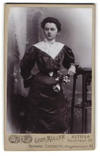 Fotografie Gebr. Müller, Altona, Schulterblatt 55, Hübsche Dame in tailliertem Kleid mit Kette u. Rose