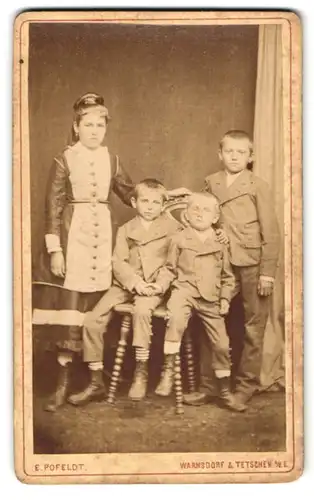 Fotografie Ernst Pofeldt, Tetschen a. d. Elbe, Schiffsgasse 172, Mädchen in geknöpftem Kleid mit drei kleinen Brüdern