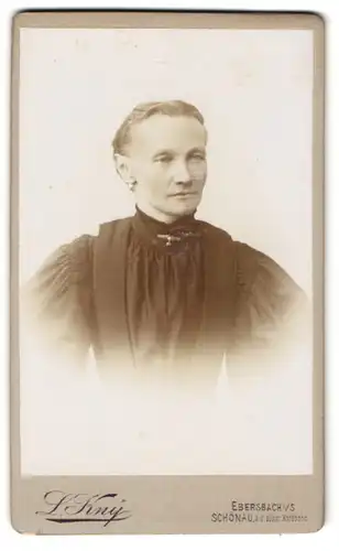 Fotografie L. Kny, Ebersbach i. S., Bürgerliche Dame im schwarzen Kleid mit Puffärmeln mit adrett frisiertem Haar