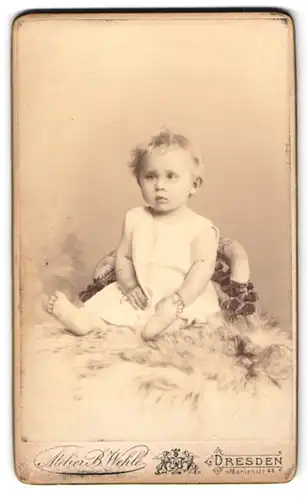 Fotografie Atelier B. Wehle, Dresden, Marienstr. 44, Kleinkind im weissen Gewand mit einem verwirrten Gesichtsausdruck