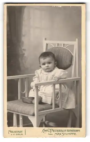 Fotografie Chr. Petersen, Neustadt a. d. Orla, Schillerstr. 1, Kleinkind im weissen Kleid mit einem fragenden Blick