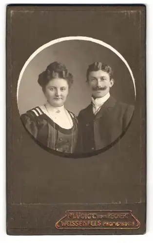 Fotografie M. Voigt, Weissenfels, Promenade 19, Junges bürgerliches Paar in dunkler feiner Kleidung mit Brosche und Bart