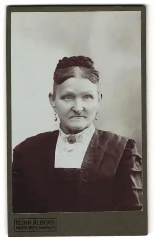 Fotografie Heinr. Albers, Harburg, Maretstr. 1, Ältere Dame im schwarzen Kleid mit hochgestecktem Haar und ernstem Blick