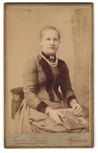 Fotografie Theodor Bässler, Meerane, Steingasse 2, Junge Dame im dunklen Kleid mit breiter Perlenkette und Buch