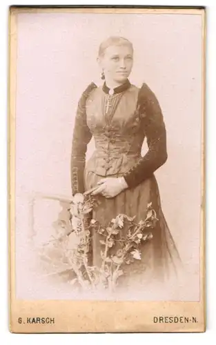 Fotografie G. Karsch, Dresden, Gr. Meissenerstr. 17, Junge Dame im dunklen Kleid mit Kreuzkette sanft am Lächeln