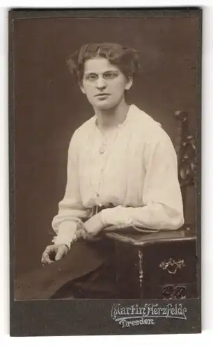 Fotografie Martin Herzfelde, Dresden, Junge Dame in weisser Bluse mit Brille und Kette leicht am Schielen