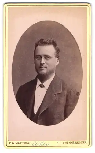 Fotografie E. W. Matthias, Seifhennersdorf, Junger gutaussehender Herr im Anzug mit Brille und Kinnbart