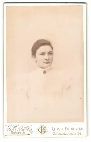 Fotografie G. B. Gäbler, Leipzig, Dolitzscherstr. 24, Schöne junge Dame im weissen Kleid mit Brosche und rundem Gesicht