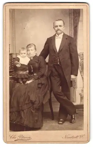 Fotografie Chr. Petersen, Neustadt a. O., Bahnhofstr. 70, Bürgerliches Ehepaar in Sonntagsgarderobe mit ihrem Kind