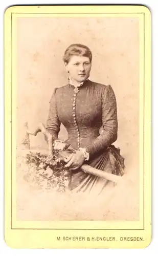 Fotografie M. Scherer & H. Hengler, Dresden, Prager-Str. 34, Junge Dame im taillierten Kleid mit einer Blüte am Kragen