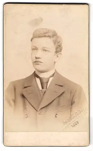 Fotografie H. Eckert, Prag, Elegant gekleideter Herr mit Brille