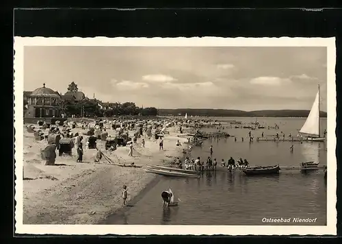 AK Niendorf / Ostsee, Belebte Szene am Strand mit einem Segelboot