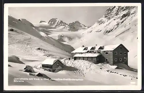 AK Jamtalhütte, verschneite Berghütte mit Vorderer und Hinterer Jamspitze-Dreiländerspitze-Silvretta