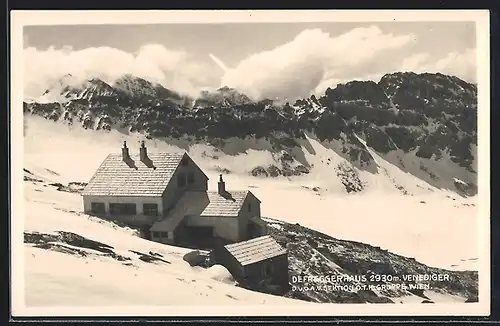 AK Defreggerhaus, Berghütte mit teilweise mit Schnee bedeckter Umgebung