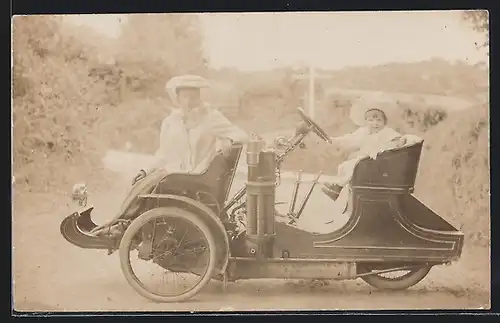 Foto-AK Auto Phoenix (1906 /07), Junge Mutter mit Kleinkind am Steuer des parkenden Wagens