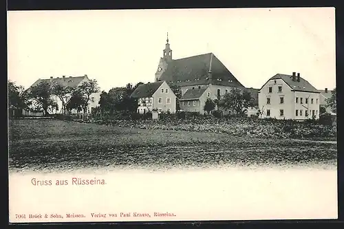 AK Rüsseina, Ortspanorama mit Kirche von einem Feld aus