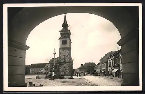 AK Gutenfeld, Platz mit Turm und Denkmal, durch ein Tor gesehen