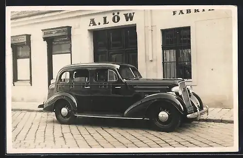 Foto-AK Chevrolet Master (1935), Wagen parkt vor dem Laden A. Löw