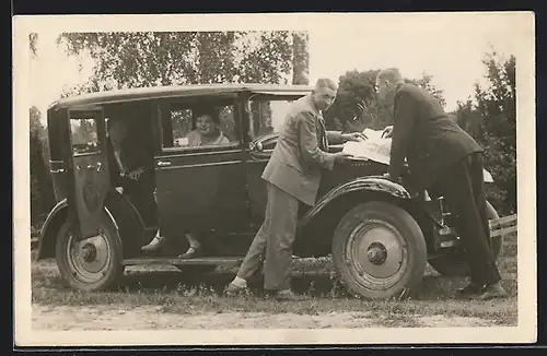 Foto-AK Auto Chevrolet (1927), Männer schlagen die Karte auf der Motorhaube auf