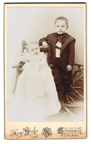 Fotografie Hugo Graf, Schedewitz b. Zwickau, Kleiner Junge im Matrosenanzug mit Kleinkind