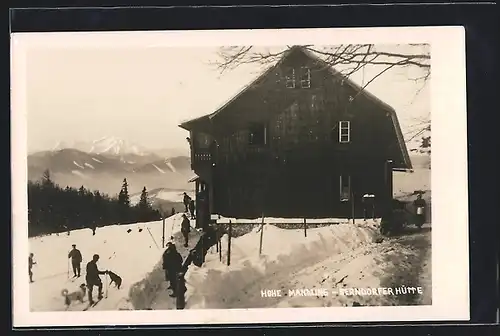 AK Berndorfer Hütte im Schnee mit Skifahrern und Hunden