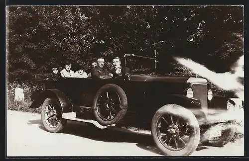 Foto-AK Auto Presto (1923 /24), Familie an Bord eines schwarzen Fahrzeugs mit offenem Verdeck auf einer Landstrasse