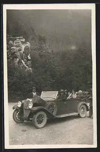 Foto-AK Auto Fiat 519 (1925), Ausflugsgruppe in einem Cabrio an einem Felsendenkmal