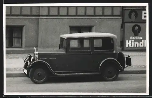 Foto-AK Auto Hanomag (1931), Fahrzeug parkt am Strassenrand vor Reklame Berliner Kindl
