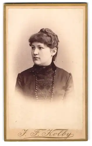 Fotografie J. F. Kolby, Zwickau, Kaiser Wilhelm Platz 31, Junge hübsche Frau im schwarzen Kleid mit Hochsteckfrisur