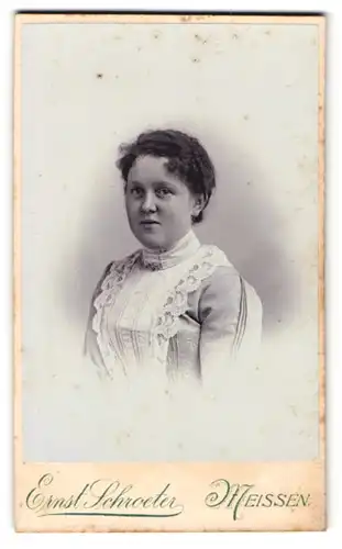 Fotografie Ernst Schroeter, Meissen, Obergasse 597, Junge Dame im hellen Spitzenkleid mit rundem Gesicht am Lächeln