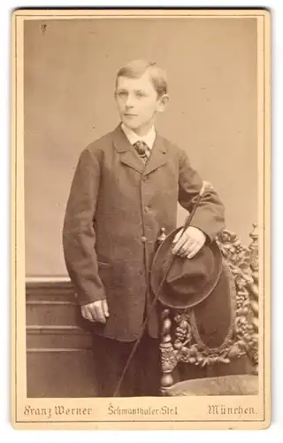 Fotografie Franz Werner, München, Schwanthalerstr. 1, Eleganter Jüngling im dunklen Anzug mit Hut und Gehstock