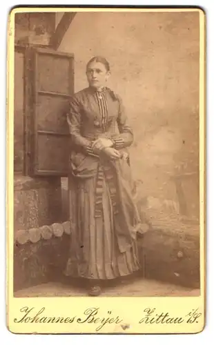 Fotografie Johannes Beyer, Zittau, Junge Dame im dunklen Kleid mit Streifen hält sich an der Hand