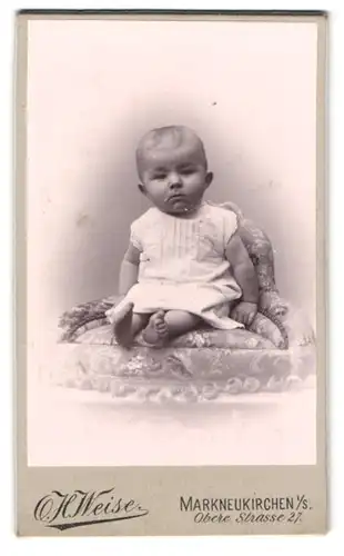 Fotografie H. Weise, Markneukirchen, Obere Str. 27, Süsses Baby im weisse Kleid mit rundem Kopf und seichtem Haar