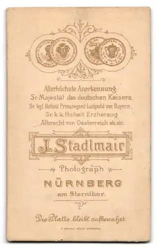 Fotografie J. Stadlmair, Nürnberg, Eleganter junger Herr im schwarzen Anzug mit dunklem Schnurrbart und Seitenscheitel