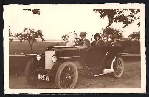 Foto-AK Auto AGA 6 /16 (1921), Zwei Herren und eine Dame fahren über eine Landstrasse